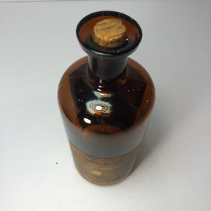 View from above. Orange extract bottle with cork.